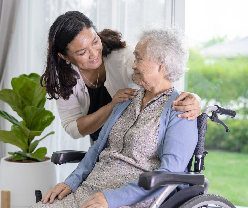 femme âgée en fauteuil roulant et son aidante